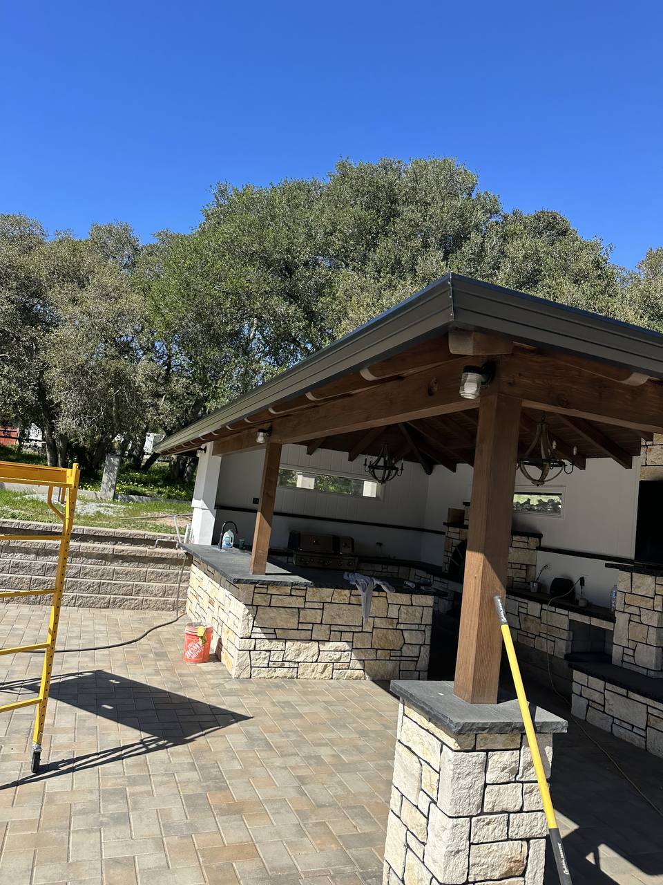 Clean finished roofline on a custom stone-pillar covered outdoor living space