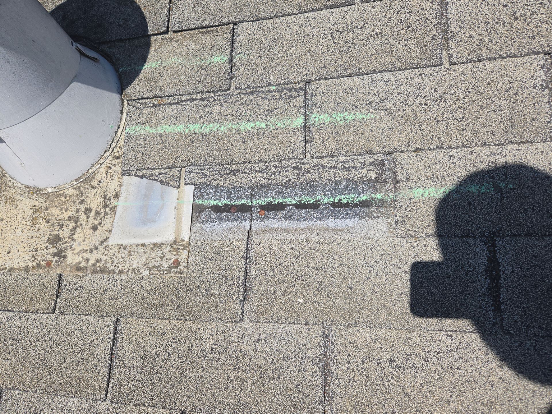 Close-up of a roof vent pipe boot with chalk-marked damage and a repair patch