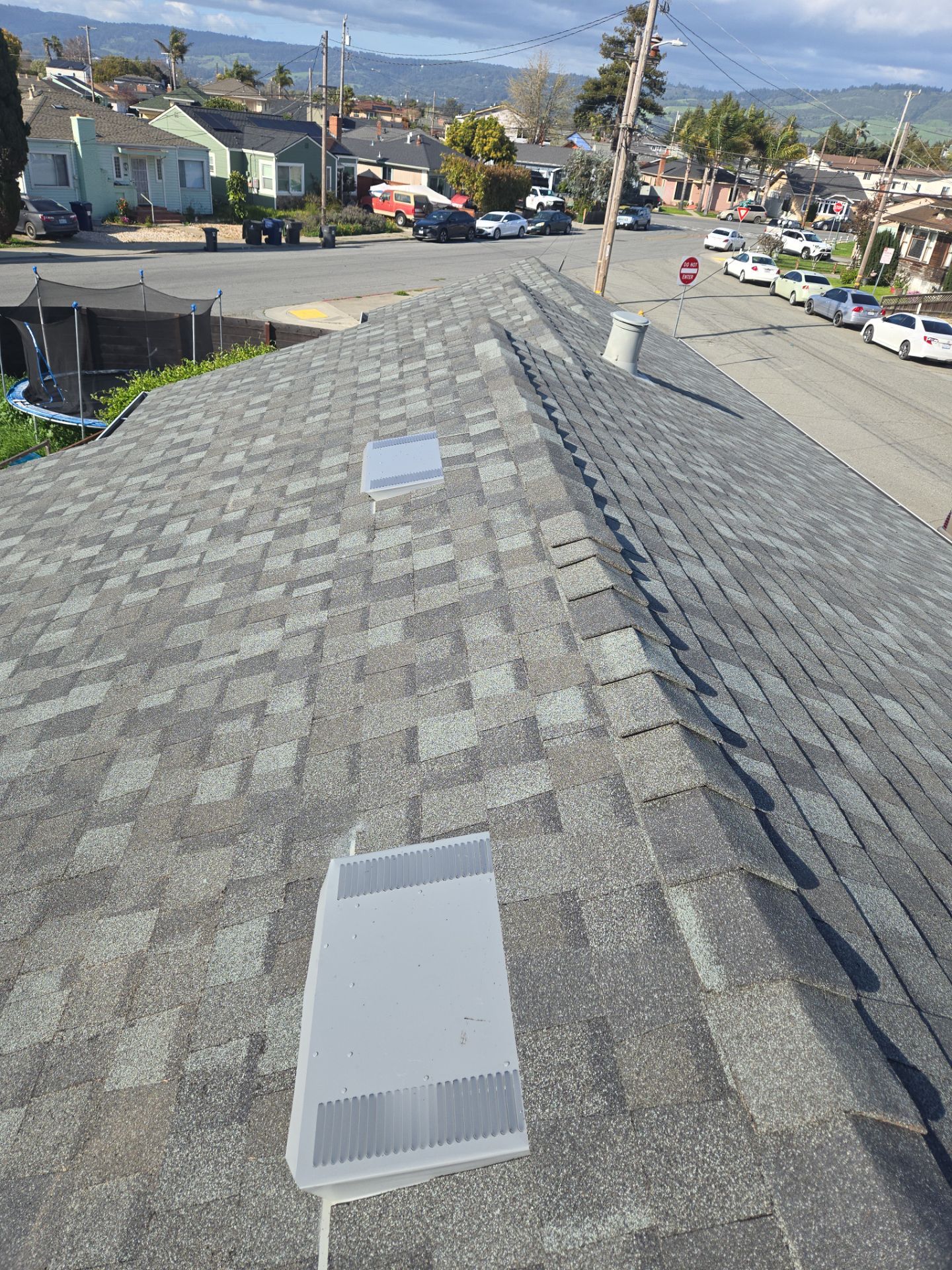 Roof vents and ridge line inspected for wind damage during an insurance claim assessment