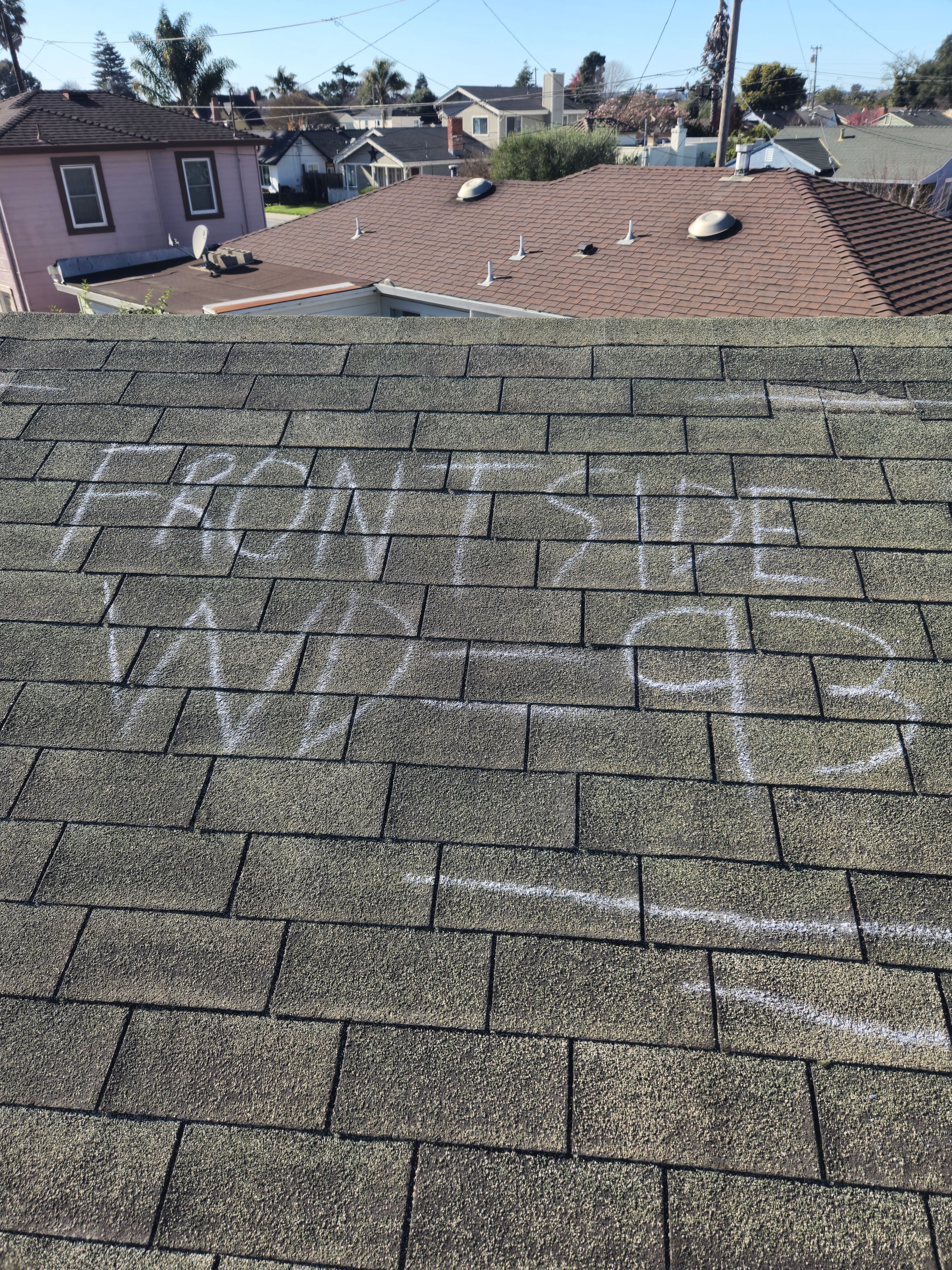 Chalk-marked wind damage labeled Front Side WD-93 documented during an insurance roof inspection
