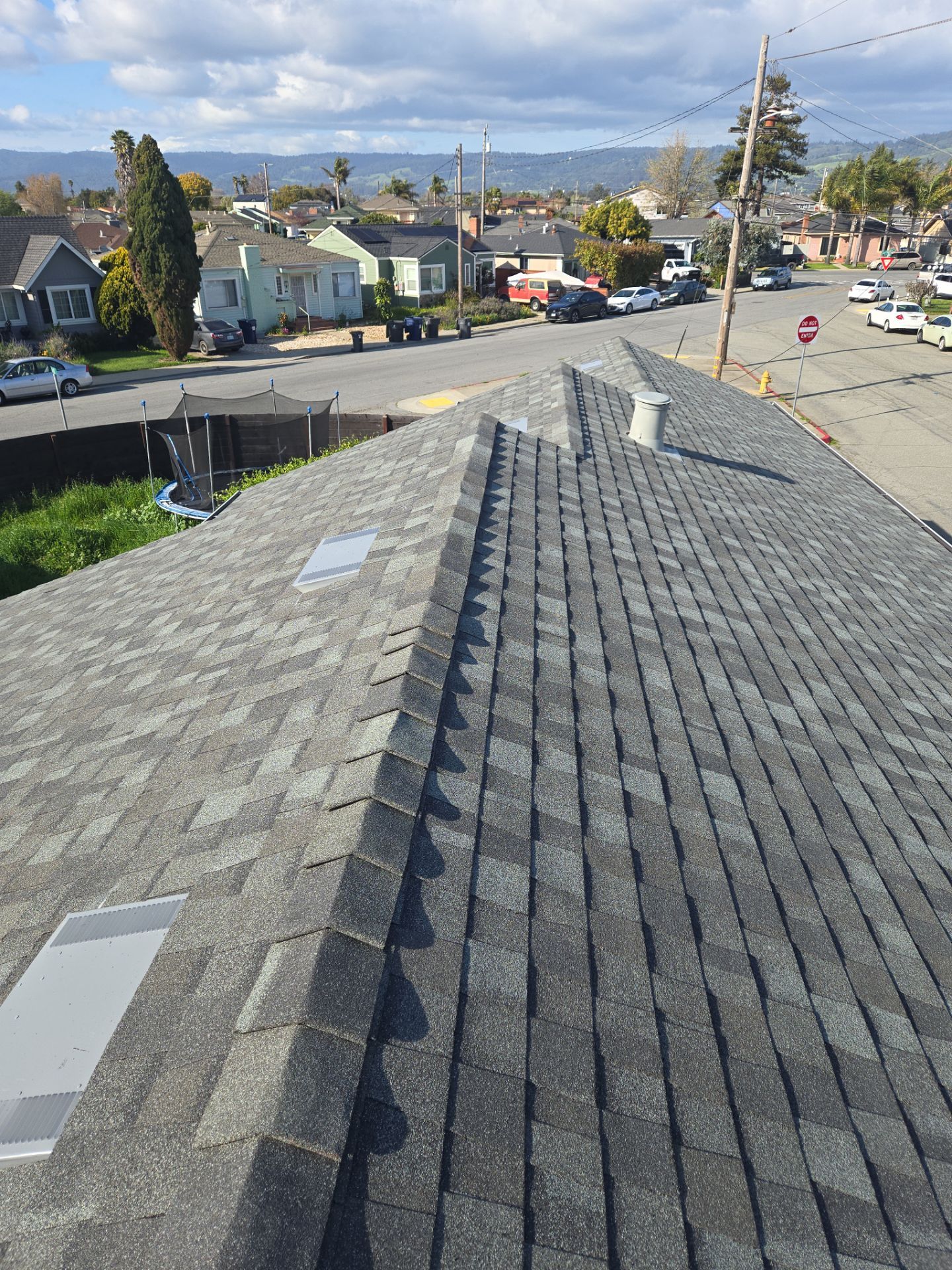 Completed new shingle roof ridge line after an approved insurance claim replacement