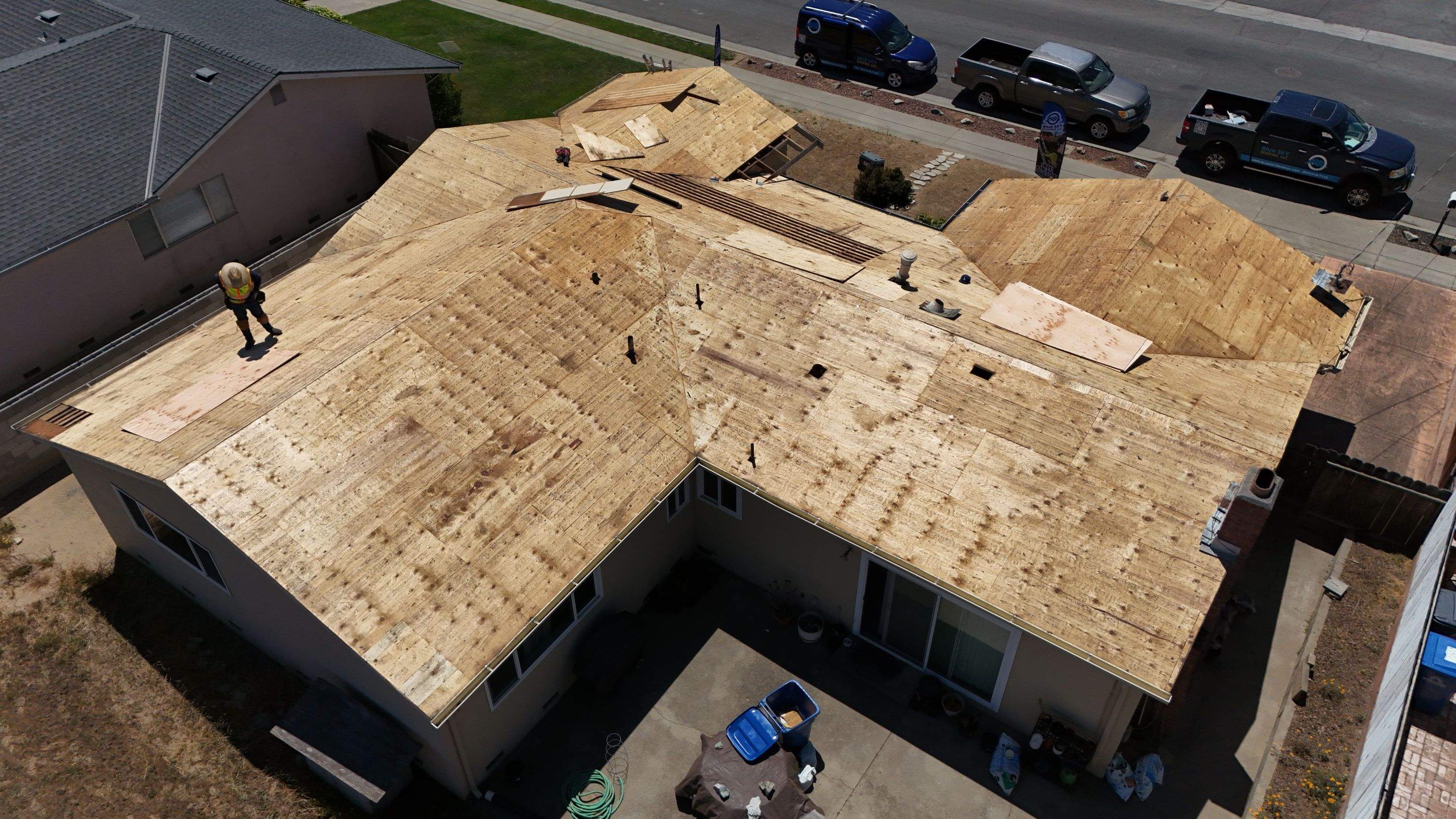 Roofing crew installing new sheathing during a roof installation project